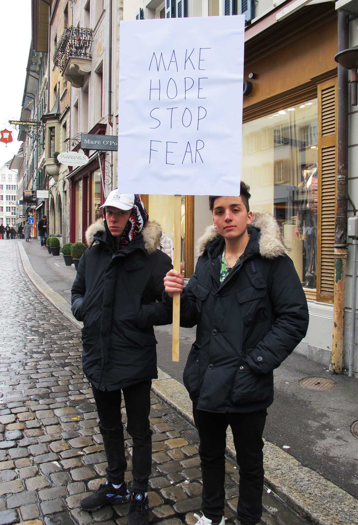 two boys hold a placard saying Make Hope Stop Fear
