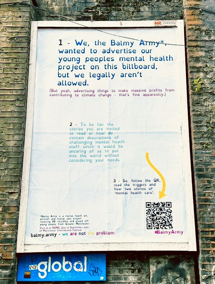 Image of a billboard against a brick wall. text saying... "1 - We, the Balmy Army* wanted to advertise our young peoples mental health project on this billboard, but we legally aren't allowed. (But yeah, advertising things to make massive profits from"