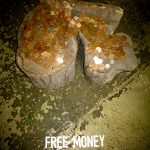 a large up ended log with coins all over the top and the words "free money" written on the floor beneath it