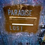 The outside of a letterbox which has been spray painted gold with the words 'paradise lost' stencilled out