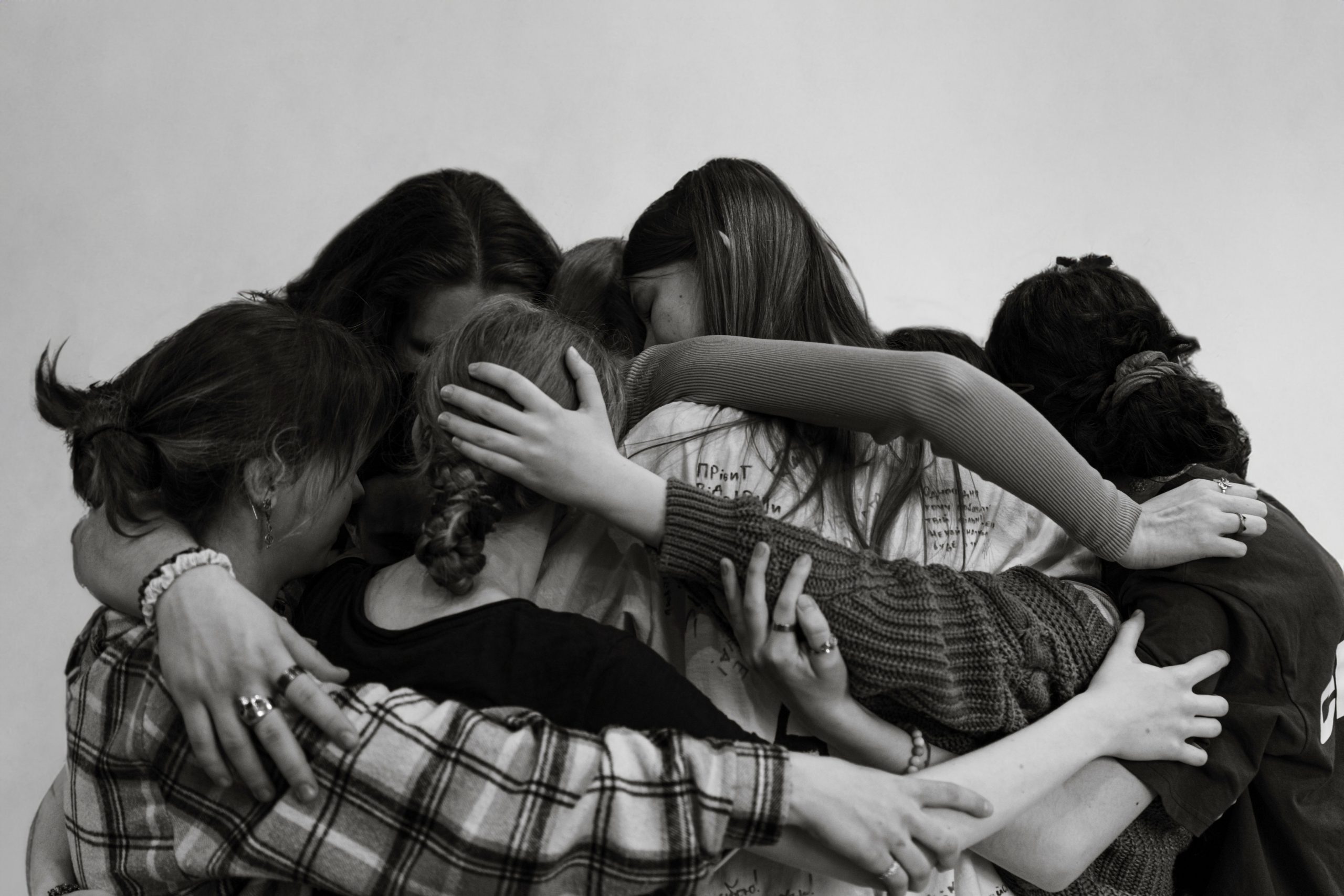 A group of ten teenagers hug each other.